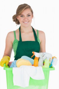 Portrait of young maid carrying cleaning supplies over white background